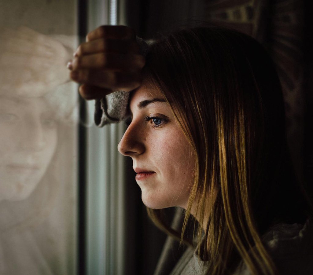 Grieving woman leaning against the window