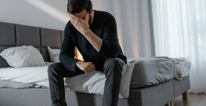 Man sitting on the bed deep in thoughts and emotions